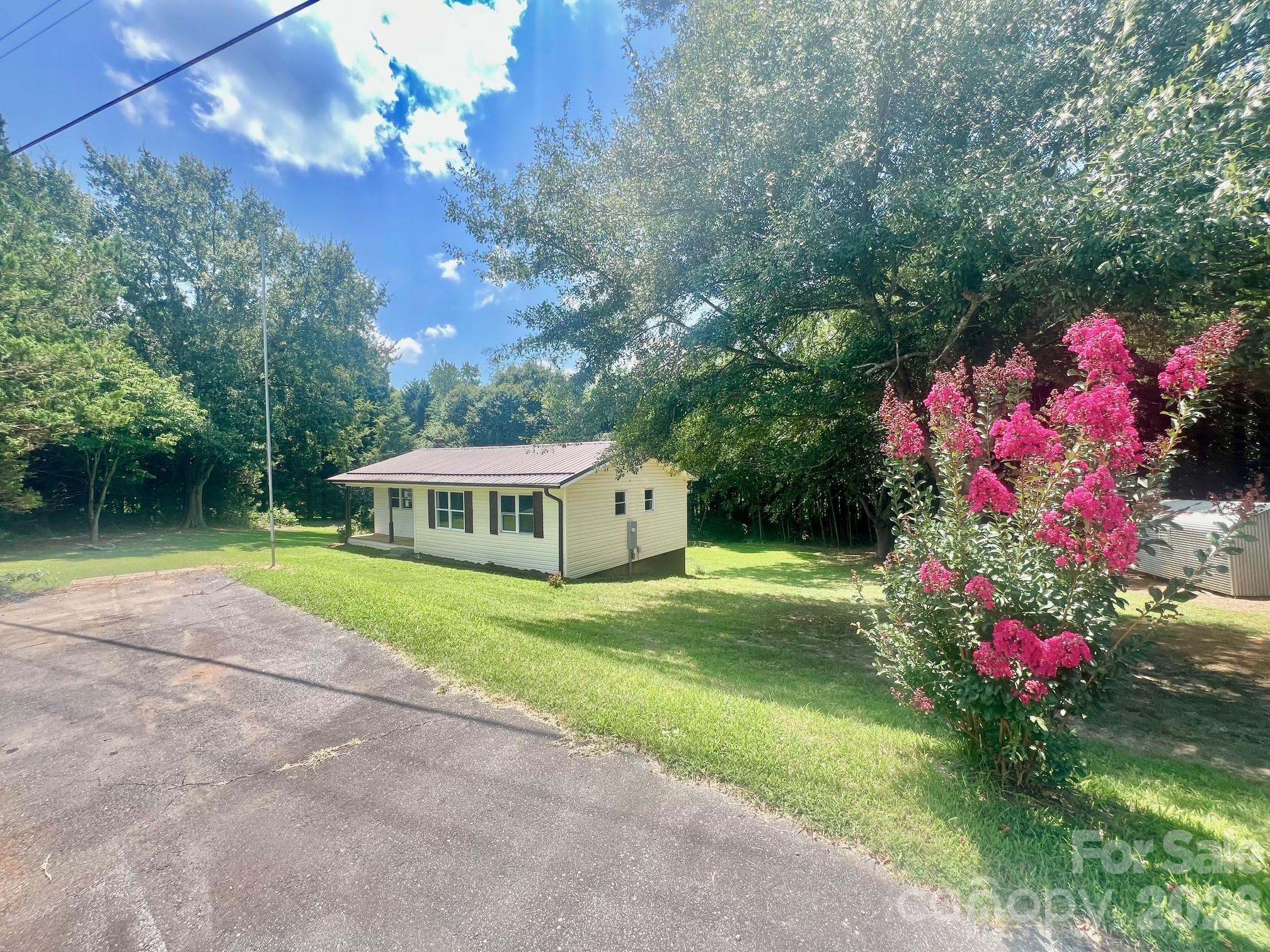 a front view of a house with a yard and potted plants