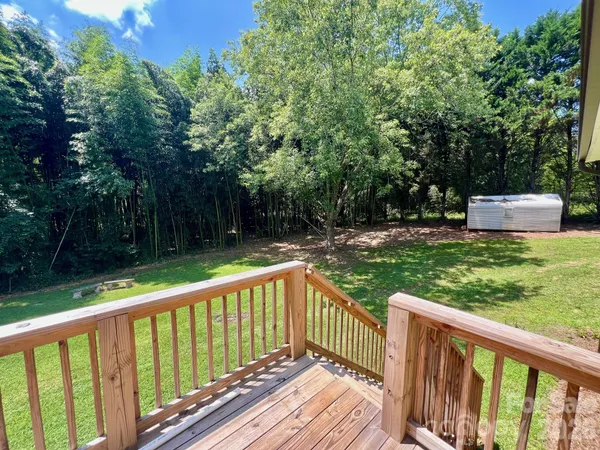 a view of a wooden deck and a yard with wooden fence