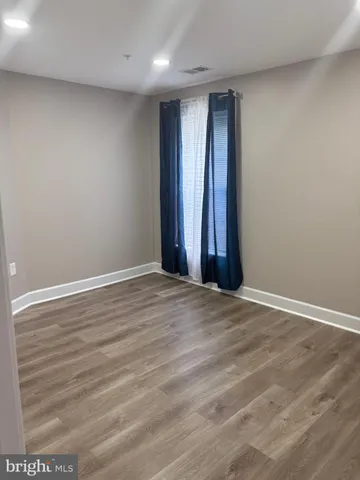 an empty room with wooden floor and window