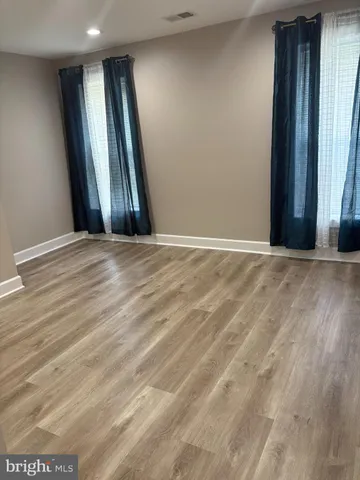 an empty room with windows and a fireplace