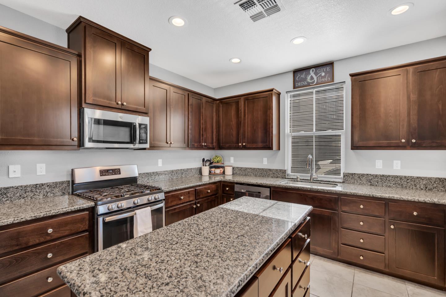 2284 Province Place Hughson, CA 95326 - Photo 19 of 53 a kitchen with granite countertop wooden cabinets and stainless steel appliances