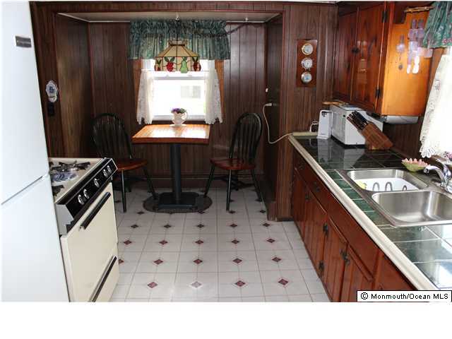 302 Church Road Brick, NJ 08723 - Photo 6 of 13 a kitchen with stainless steel appliances a sink a stove a refrigerator and a dining table