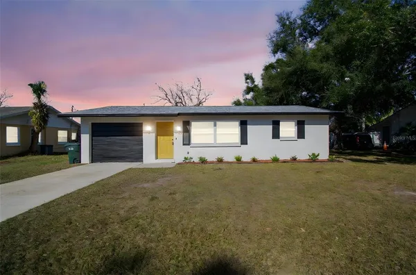 a front view of a house with a garden and yard