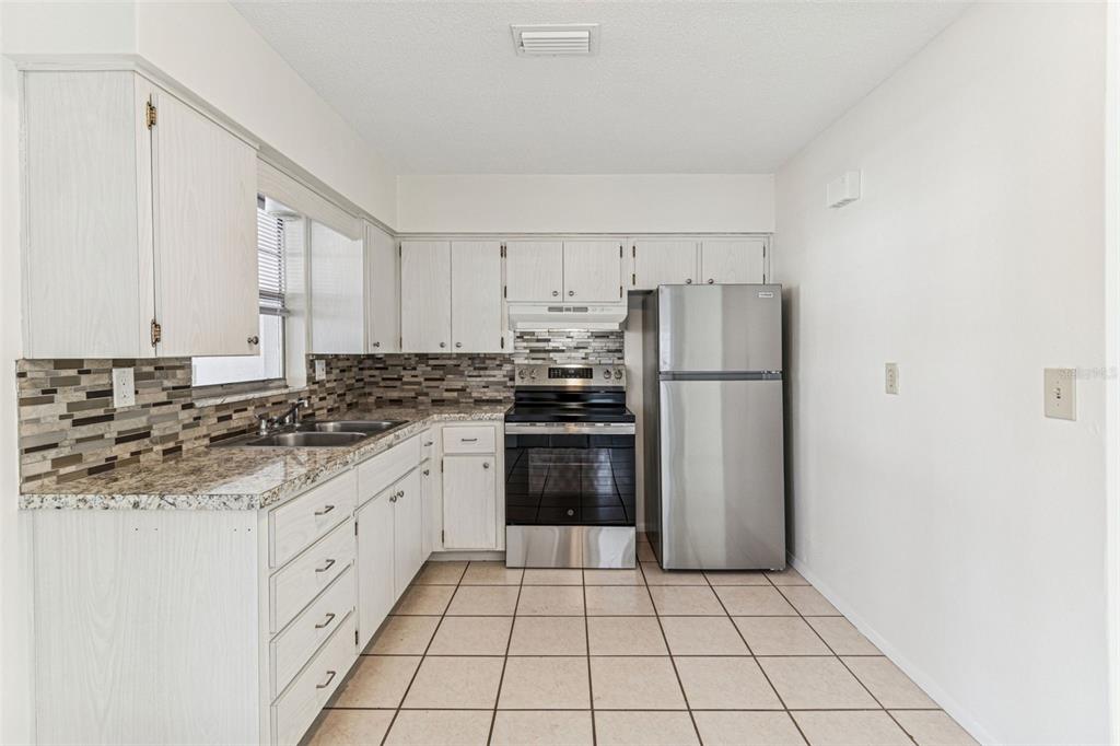 822 3rd Avenue Northwest Largo, FL 33770 - Photo 16 of 75 a kitchen with stainless steel appliances a refrigerator sink and cabinets