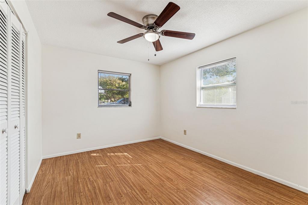 822 3rd Avenue Northwest Largo, FL 33770 - Photo 30 of 75 an empty room with wooden floor and ceiling fan