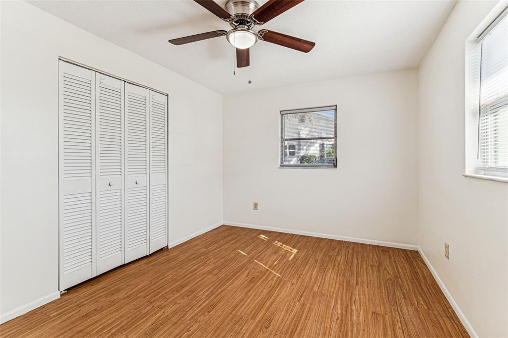 822 3rd Avenue Northwest Largo, FL 33770 - Photo 31 of 75 an empty room with wooden floor chandelier fan and windows