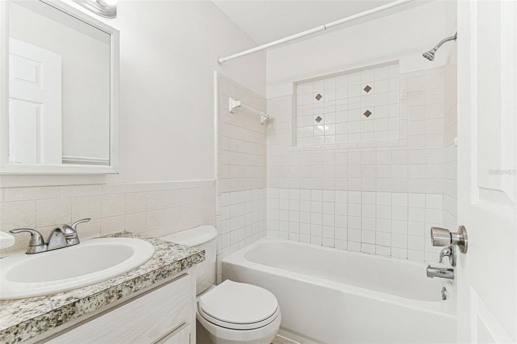 822 3rd Avenue Northwest Largo, FL 33770 - Photo 34 of 75 a bathroom with a granite countertop bathtub shower sink mirror vanity and toilet