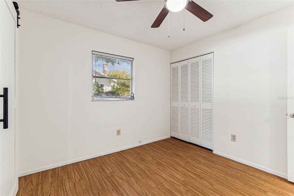 822 3rd Avenue Northwest Largo, FL 33770 - Photo 38 of 75 an empty room with wooden floor chandelier fan and windows