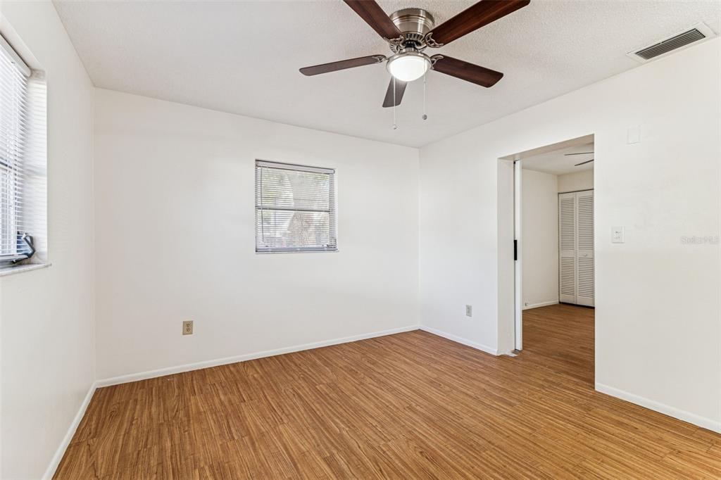 822 3rd Avenue Northwest Largo, FL 33770 - Photo 46 of 75 an empty room with wooden floor and a ceiling fan