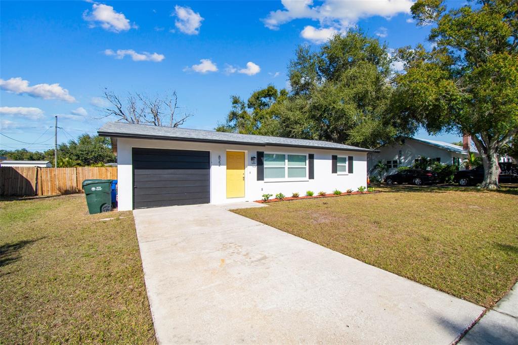 822 3rd Avenue Northwest Largo, FL 33770 - Photo 5 of 75 a front view of house with yard and trees in the background