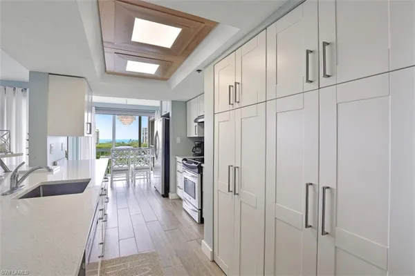 a hallway with white cabinets and wooden floor