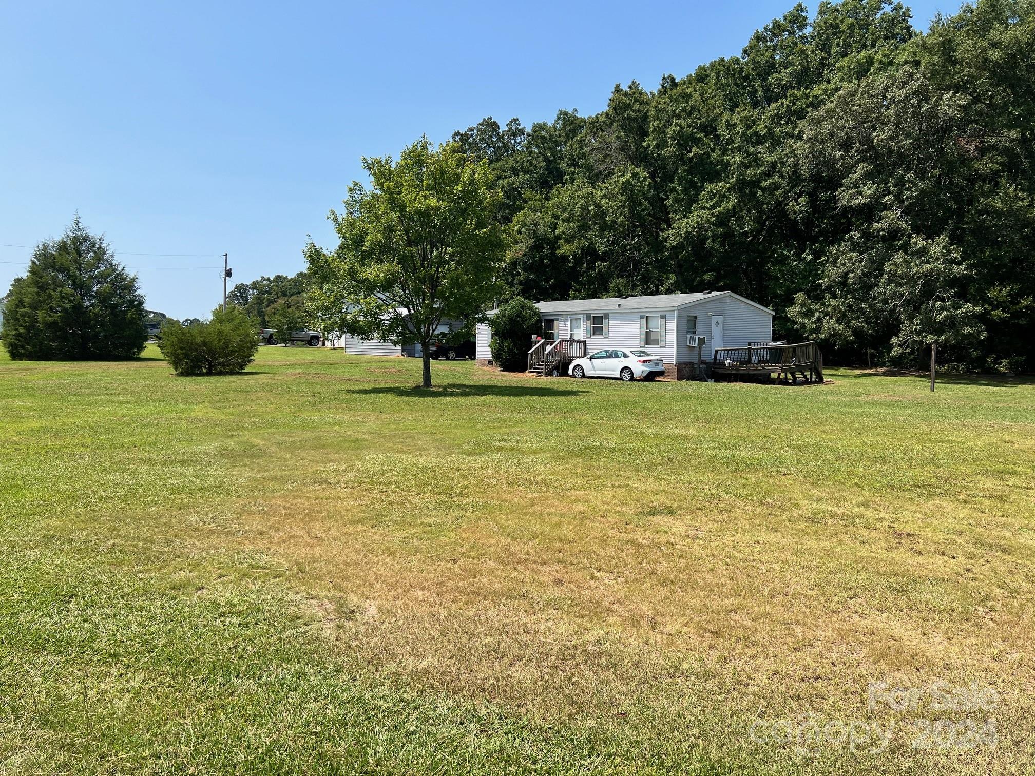 414 Drye Road Polkton, NC 28135 - Photo 1 of 12 a swimming pool is sitting in a big yard with large trees