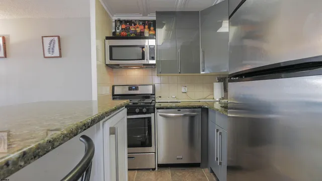 a kitchen with granite countertop a stove and a wooden cabinets