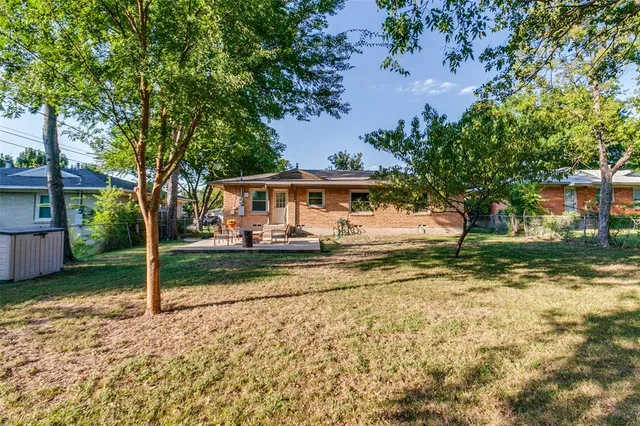 a view of a house with backyard and tree
