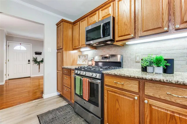 a kitchen with stainless steel appliances granite countertop a stove a sink and a microwave