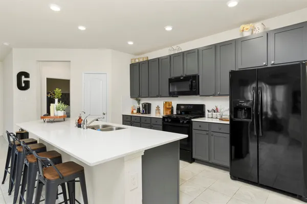 a kitchen with a sink a kitchen island and stainless steel appliances