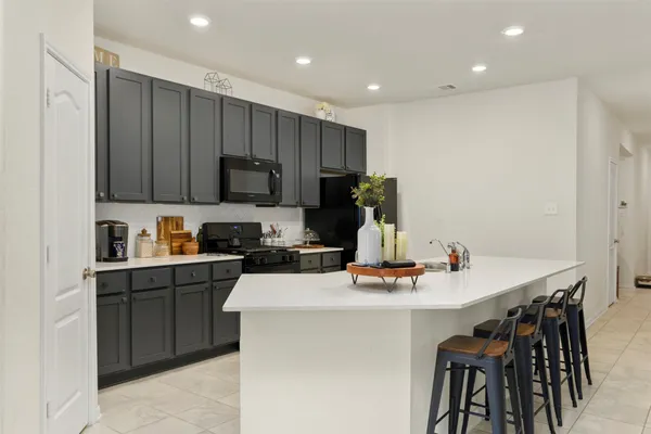 a kitchen with a sink a stove and chairs