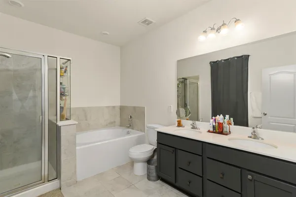 a bathroom with a tub double sink shower and mirror