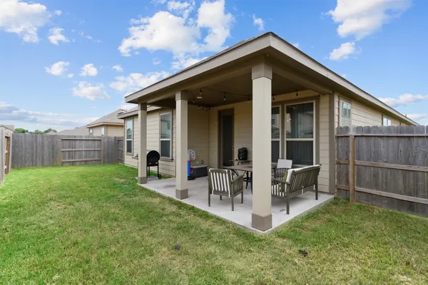 a backyard of a house with table and chairs