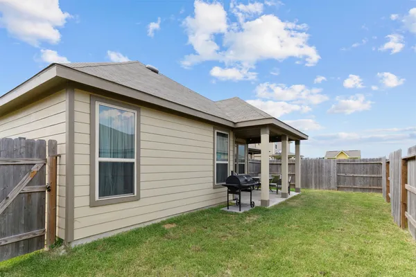 a backyard of a house with table and chairs