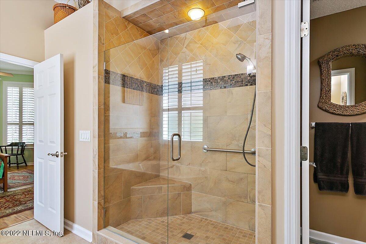 184 Edge Of Woods Road St. Augustine, FL 32092 - Photo 14 of 24 a bathroom with a glass shower door and a mirror