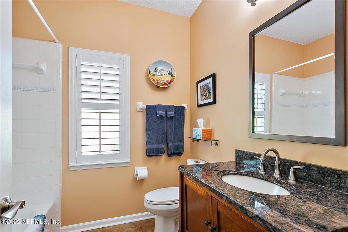 184 Edge Of Woods Road St. Augustine, FL 32092 - Photo 16 of 24 a bathroom with a granite countertop sink mirror vanity and a toilet