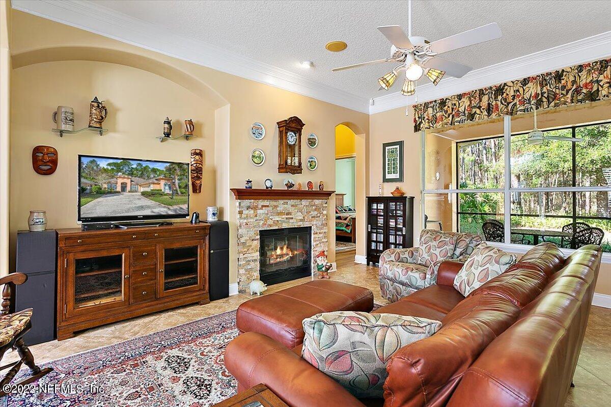184 Edge Of Woods Road St. Augustine, FL 32092 - Photo 6 of 24 a living room with furniture a flat screen tv and a fireplace