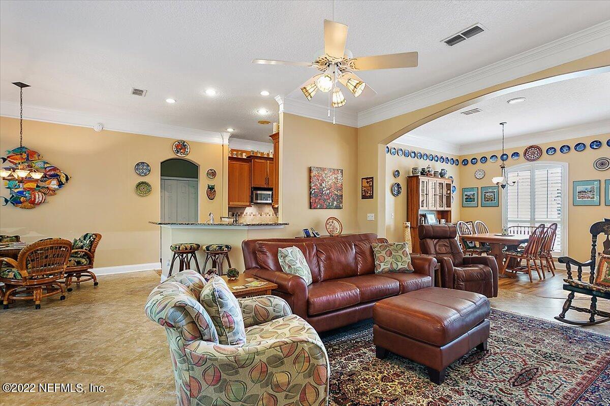 184 Edge Of Woods Road St. Augustine, FL 32092 - Photo 8 of 24 a living room with furniture kitchen view and a chandelier