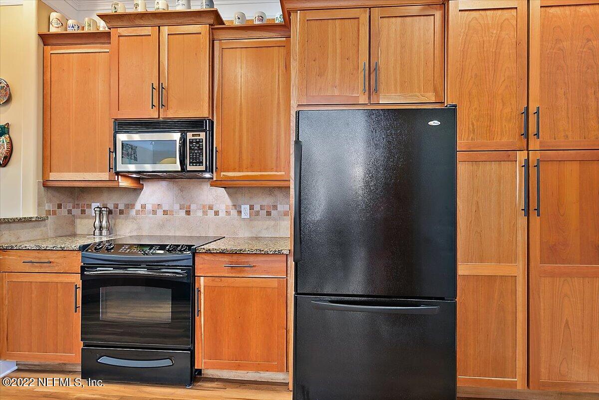 184 Edge Of Woods Road St. Augustine, FL 32092 - Photo 10 of 24 a kitchen with granite countertop a refrigerator stove and microwave