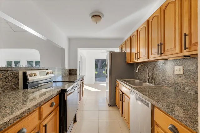 a kitchen with stainless steel appliances granite countertop a sink stove and cabinets