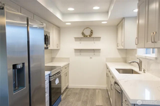 a kitchen with a sink a refrigerator and cabinets