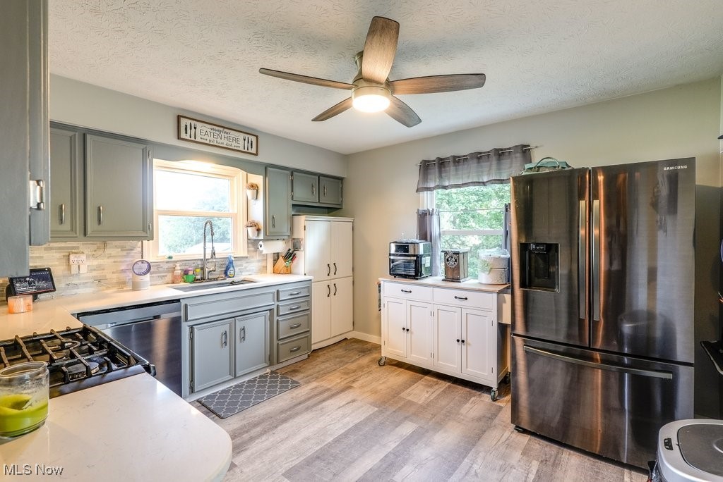 3066 Prior Road Akron, OH 44319 - Photo 11 of 50 Kitchen with a textured ceiling, appliances with stainless steel finishes, light hardwood / wood-style floors, sink, and ceiling fan