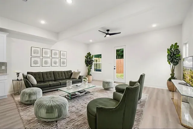 a living room with furniture and a wooden floor