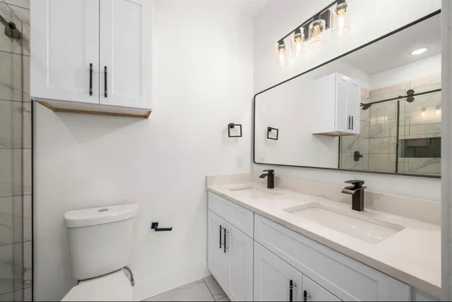 a bathroom with a sink and mirror with toilet