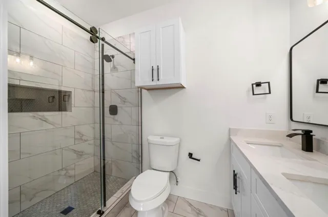 a bathroom with a sink a toilet and shower