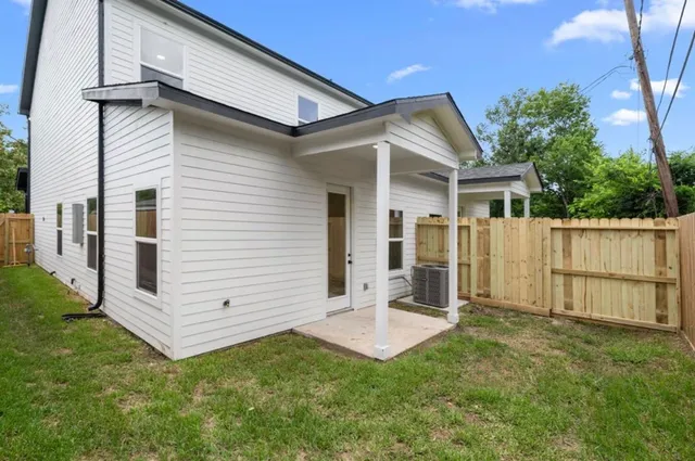a view of a house with backyard and wooden fence