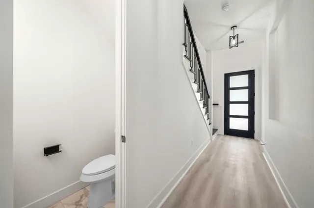 a view of a hallway with stairs and a wooden floor