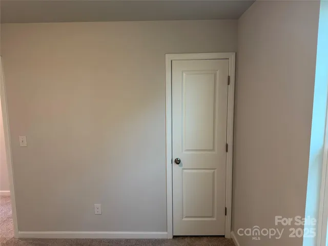 a view of a hallway with closet and window