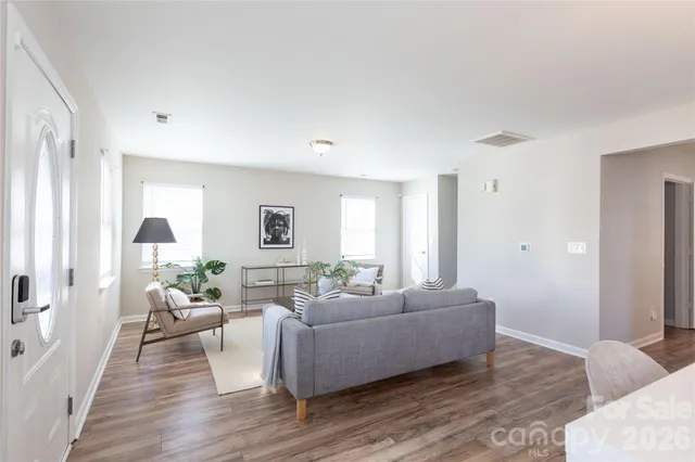 a living room with furniture and a wooden floor