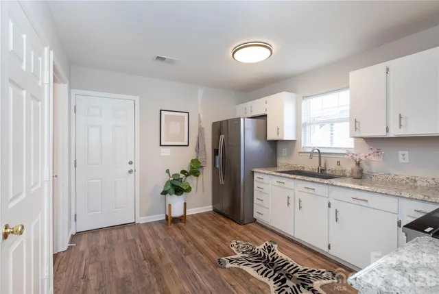 a kitchen with stainless steel appliances granite countertop a refrigerator sink and stove
