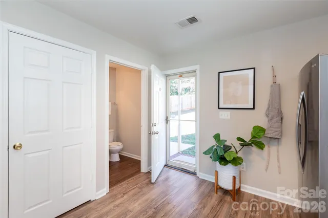 a view of a hallway with wooden floor and a bathroom view