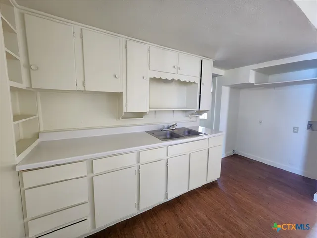 a room with white cabinets and sink