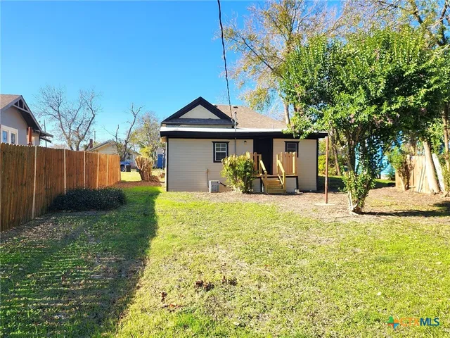a view of a backyard with a tree