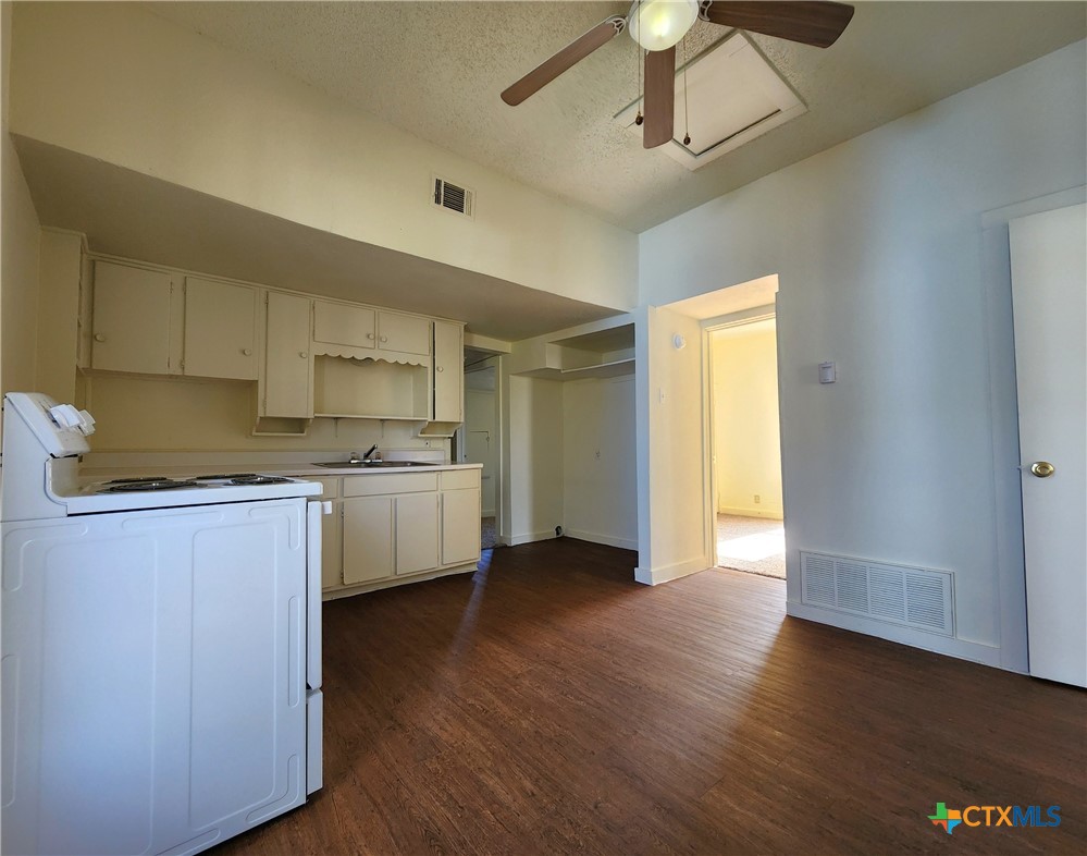 209 South 27th Street Temple, TX 76504 - Photo 10 of 26 a kitchen with a sink cabinets and wooden floor