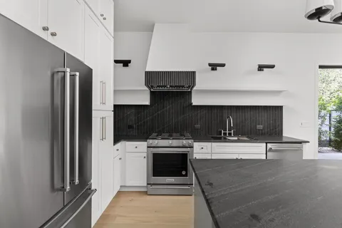 a kitchen with stainless steel appliances a stove a refrigerator and a sink