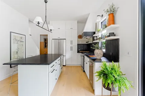 a kitchen with stainless steel appliances kitchen island granite countertop a stove a sink and a refrigerator