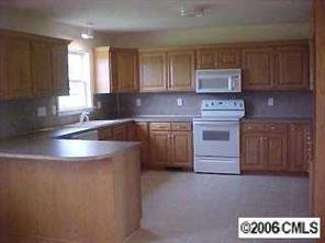 2180 River Road Woodleaf, NC 27054 - Photo 3 of 7 a kitchen with kitchen island granite countertop a sink a stove and cabinets
