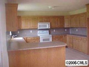2180 River Road Woodleaf, NC 27054 - Photo 4 of 7 a kitchen with stainless steel appliances granite countertop a sink a stove and a refrigerator