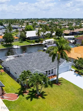 an aerial view of a house with a garden and lake view