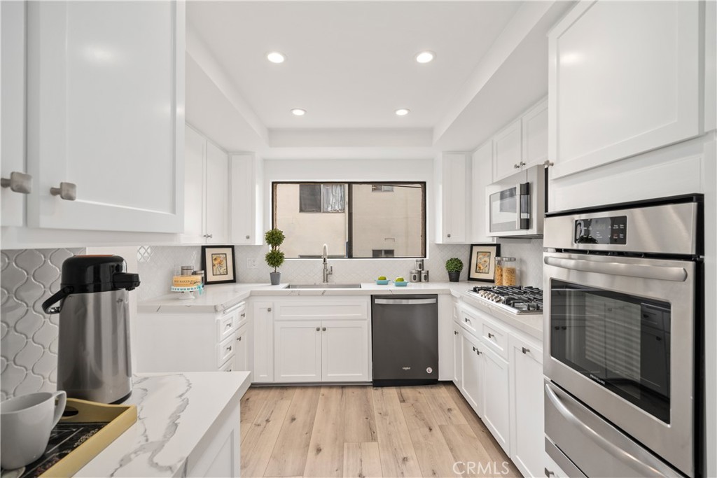 435 Fairview Avenue, Unit 7 Arcadia, CA 91007 - Photo 9 of 35 a kitchen with white cabinets sink and stainless steel appliances